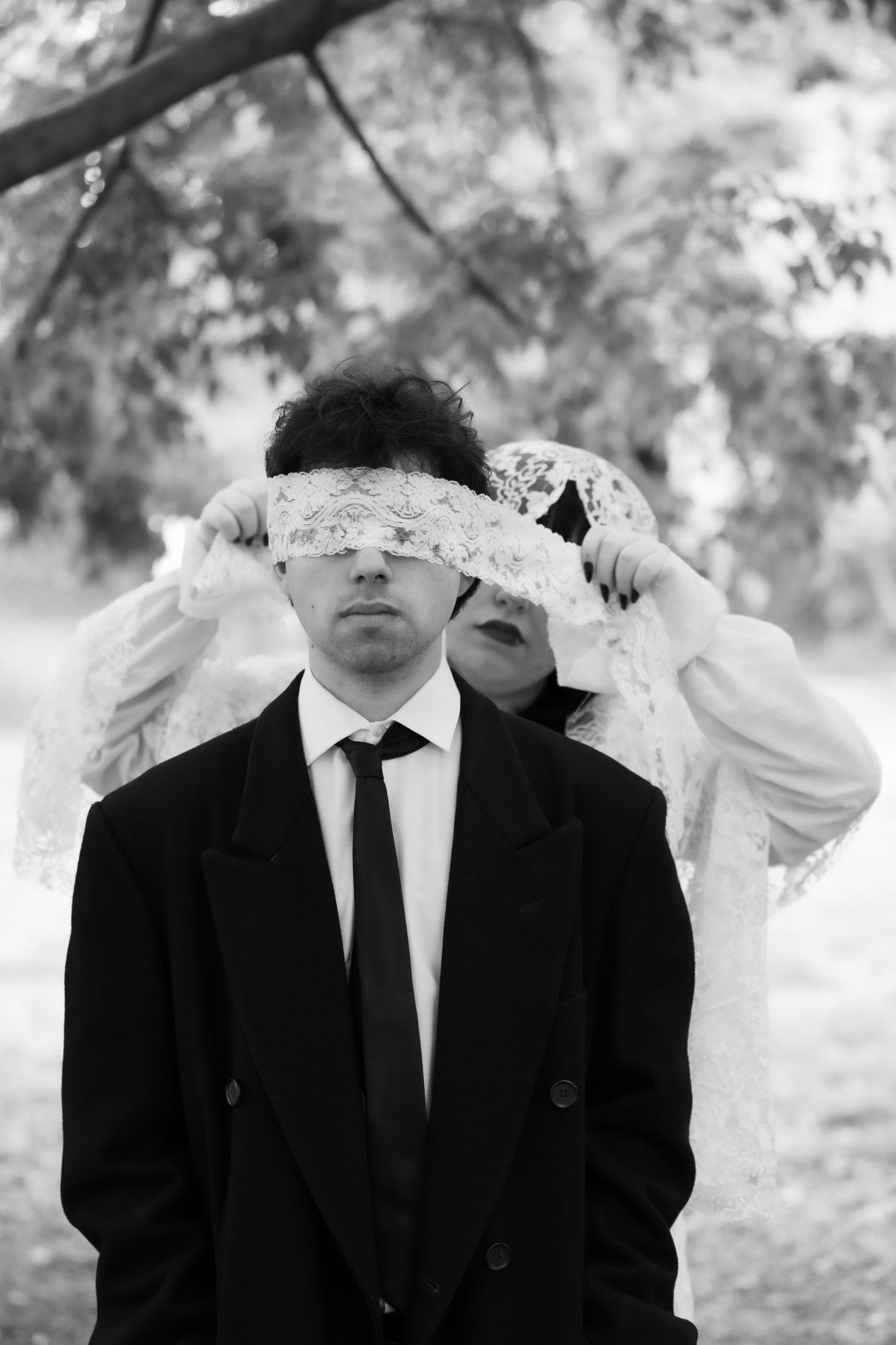 Hombre con los ojos vendados con encaje, en blanco y negro